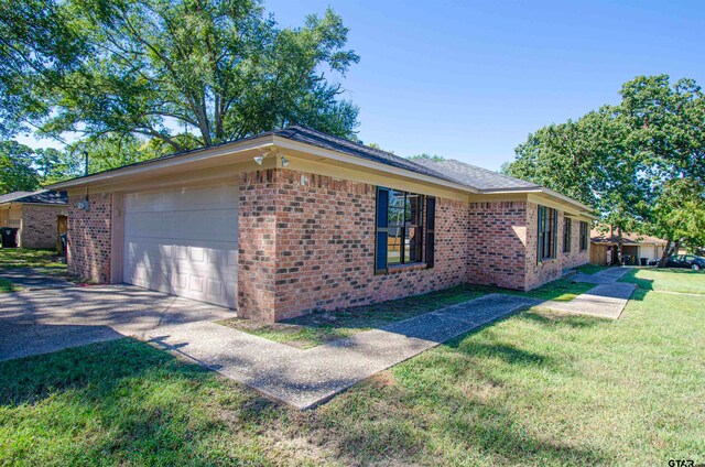 view of side of home with a garage and a lawn