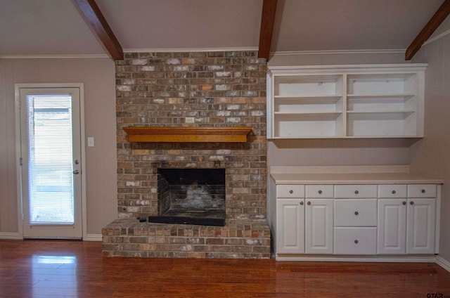 unfurnished living room featuring ornamental molding, a brick fireplace, dark hardwood / wood-style flooring, and beamed ceiling