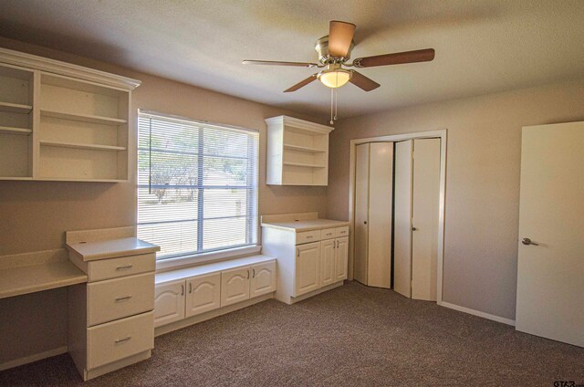 unfurnished office featuring a textured ceiling, carpet floors, and ceiling fan