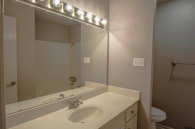 bathroom with toilet, a shower, and vanity