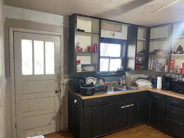 kitchen featuring a textured ceiling, hardwood / wood-style floors, and sink