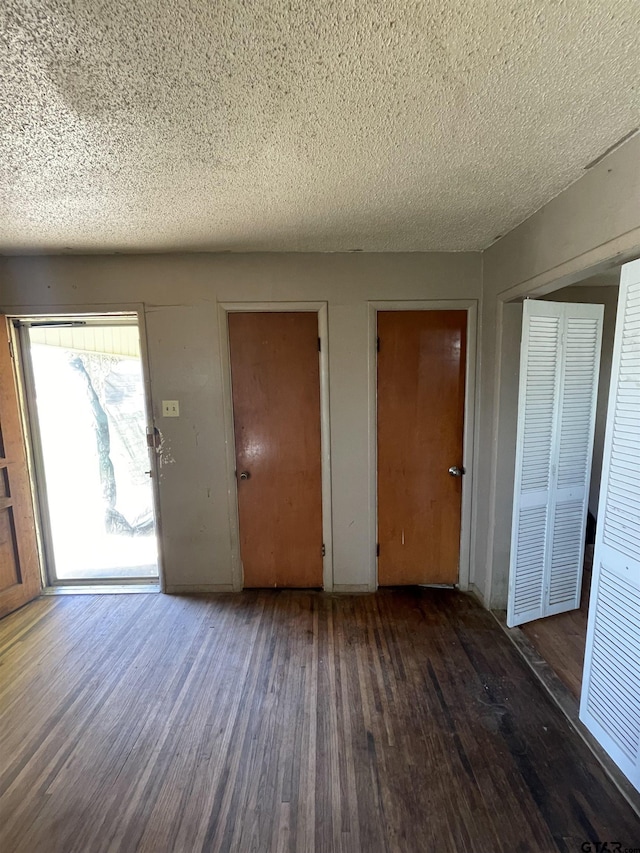 foyer entrance with dark wood-type flooring and a textured ceiling