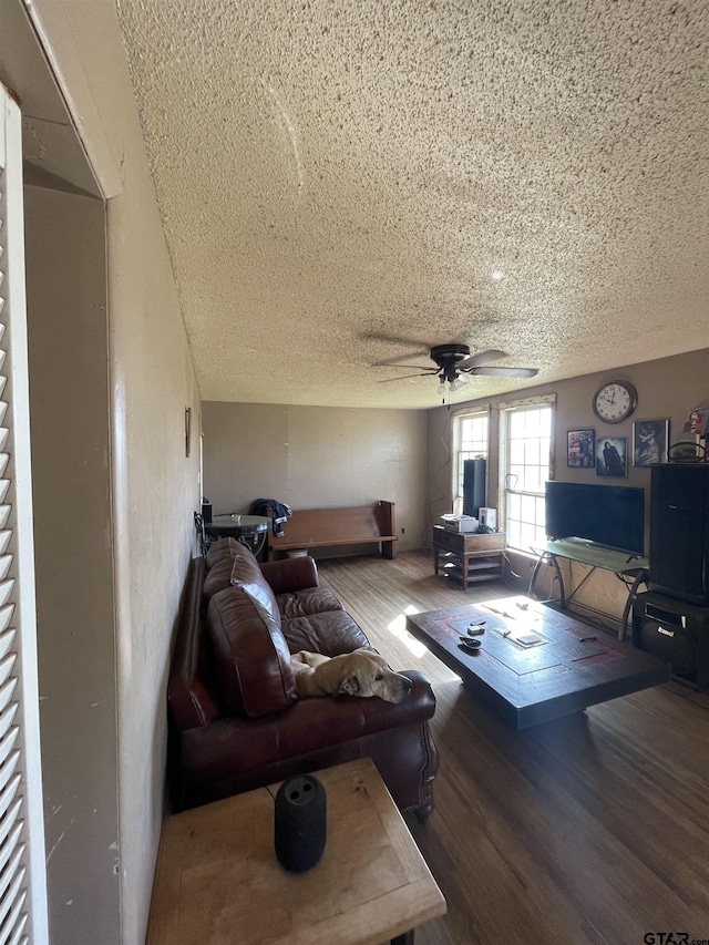 living room featuring wood-type flooring, ceiling fan, and a textured ceiling