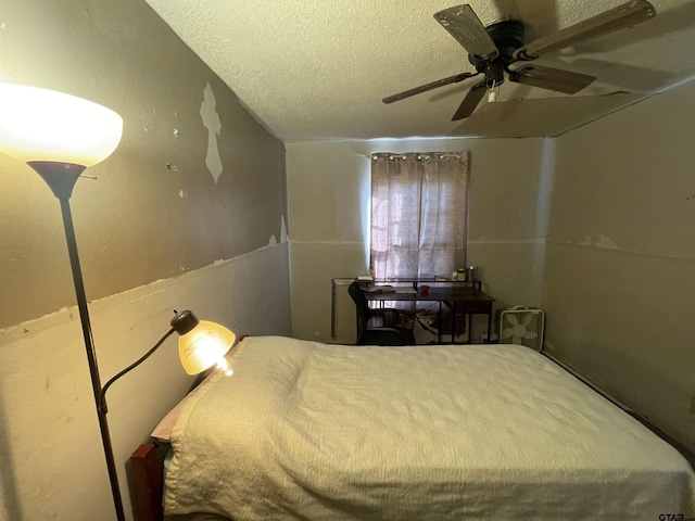 bedroom with ceiling fan and a textured ceiling