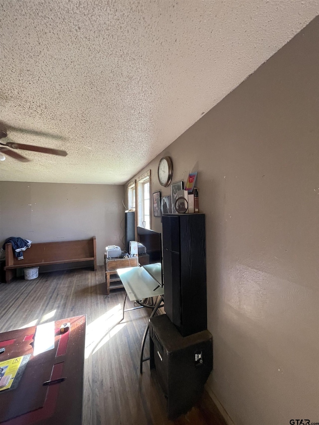 living room featuring a textured ceiling, hardwood / wood-style flooring, and ceiling fan