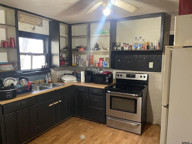 kitchen with white refrigerator, a textured ceiling, sink, light hardwood / wood-style flooring, and stainless steel electric range oven