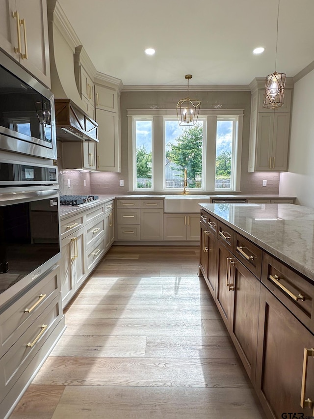 14438 Woodland Crk, Tyler, TX 75706 - kitchen with appliances with stainless steel finishes, crown molding, light stone countertops, tasteful backsplash, and pendant lighting