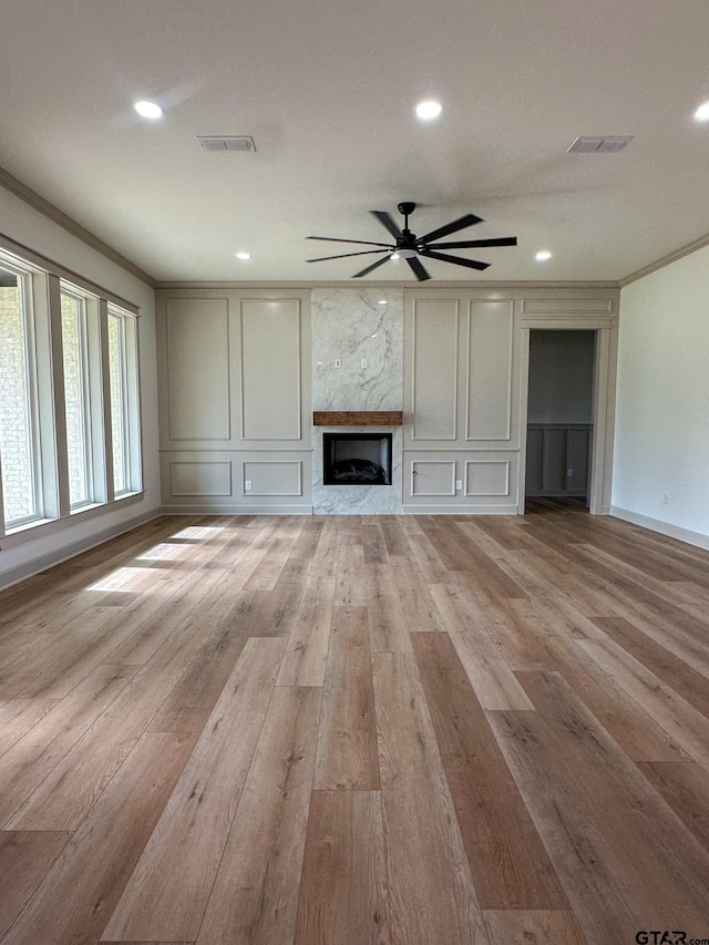 14438 Woodland Crk, Tyler, TX 75706 - unfurnished living room with ornamental molding, a ceiling fan, light wood-style floors, a high end fireplace, and recessed lighting