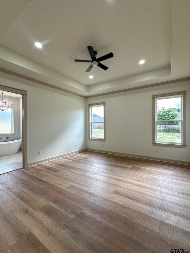 14438 Woodland Crk, Tyler, TX 75706 - empty room with a tray ceiling, light wood-type flooring, a chandelier, ceiling fan, and recessed lighting