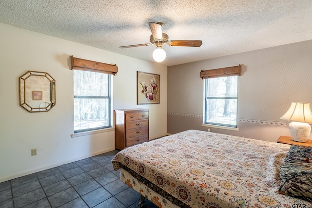 bedroom with ceiling fan, a textured ceiling, and multiple windows