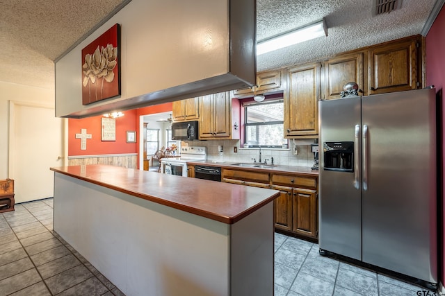 kitchen with black appliances, sink, decorative backsplash, a textured ceiling, and light tile patterned flooring