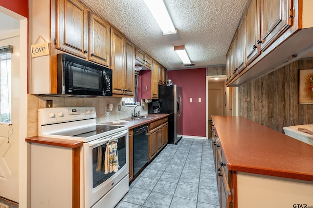 kitchen featuring black appliances, sink, decorative backsplash, light tile patterned floors, and a textured ceiling