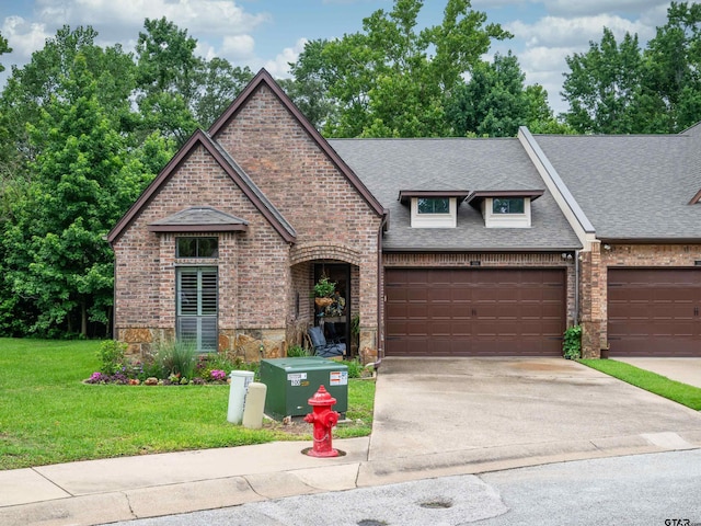 1857 Stonecrest Blvd, Tyler, TX 75703 - french country inspired facade with roof with shingles, concrete driveway, a front lawn, and brick siding