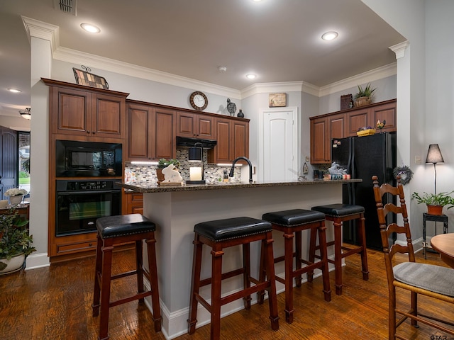 1857 Stonecrest Blvd, Tyler, TX 75703 - kitchen featuring black appliances, backsplash, a breakfast bar area, dark wood-type flooring, and ornamental molding