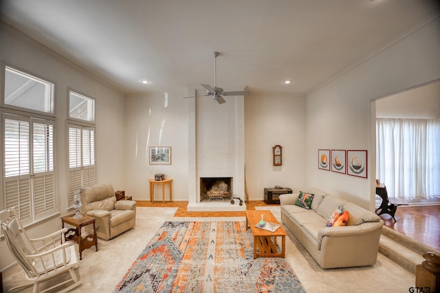 living room featuring ceiling fan, ornamental molding, and a fireplace