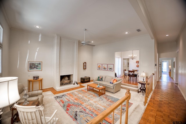 living room with ornamental molding, a brick fireplace, parquet floors, and ceiling fan with notable chandelier