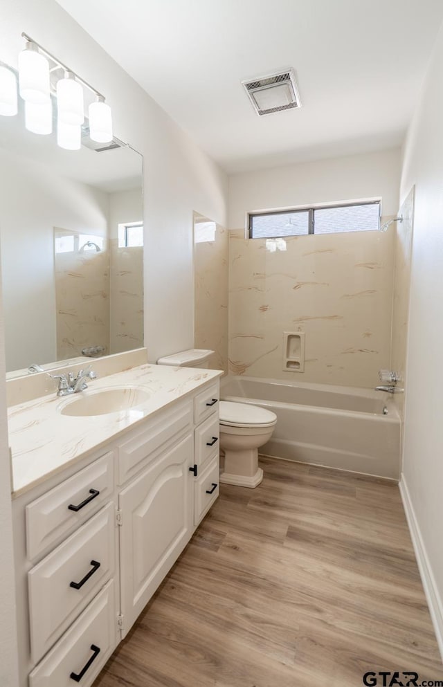 bathroom featuring shower / bathtub combination, toilet, wood finished floors, vanity, and visible vents