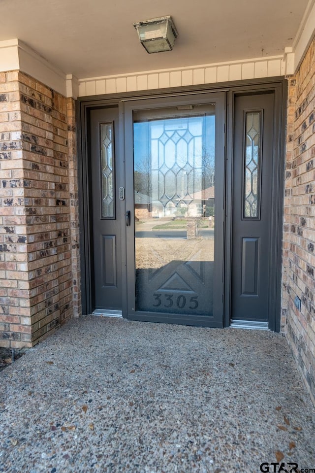 doorway to property featuring brick siding