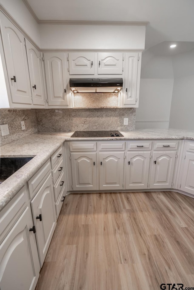 kitchen featuring white cabinets, under cabinet range hood, black electric stovetop, and light wood finished floors