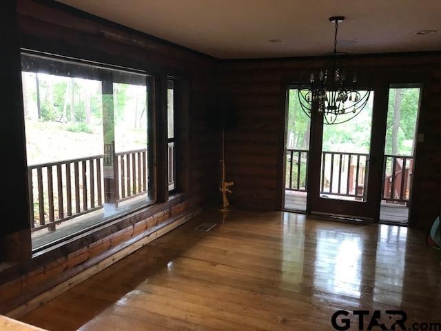 dining room with hardwood / wood-style floors, plenty of natural light, and a notable chandelier