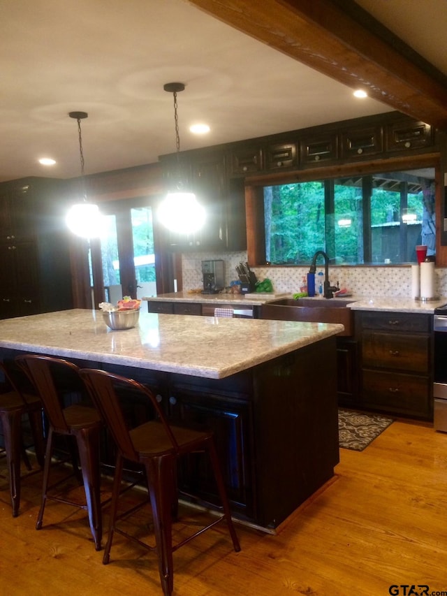 kitchen featuring light wood-type flooring, a wealth of natural light, and decorative light fixtures