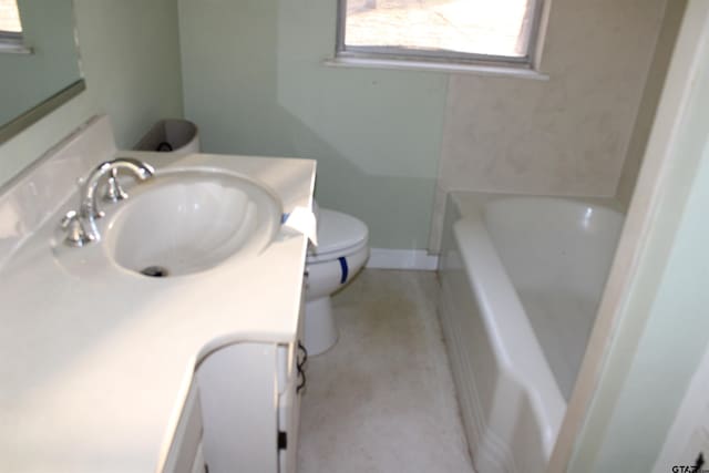 full bath featuring toilet, vanity, and a washtub