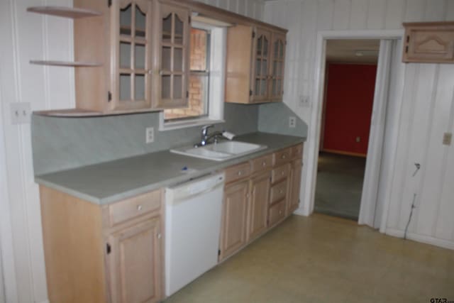 kitchen with open shelves, glass insert cabinets, light floors, white dishwasher, and a sink