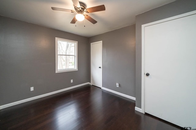 empty room featuring dark wood-type flooring and ceiling fan