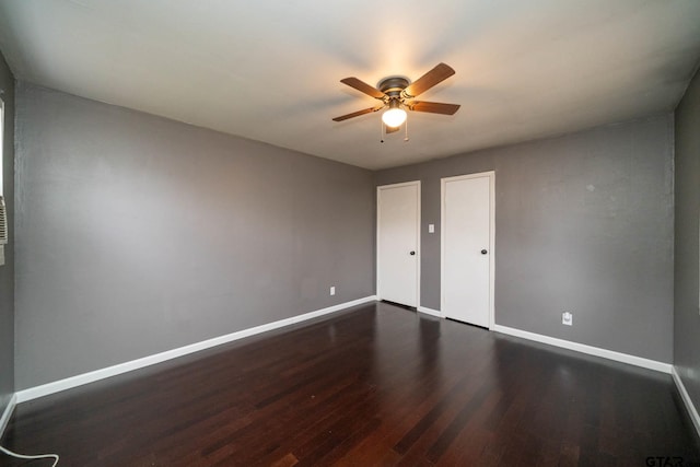 empty room with ceiling fan and dark hardwood / wood-style floors