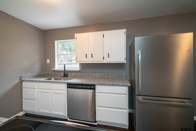 kitchen featuring appliances with stainless steel finishes, sink, and white cabinetry