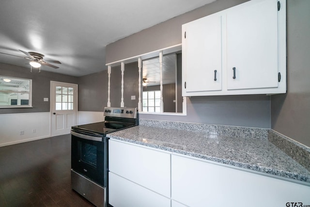 kitchen with light stone counters, white cabinets, stainless steel electric range oven, and a healthy amount of sunlight