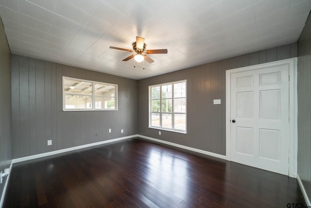 unfurnished room with ceiling fan and dark hardwood / wood-style flooring