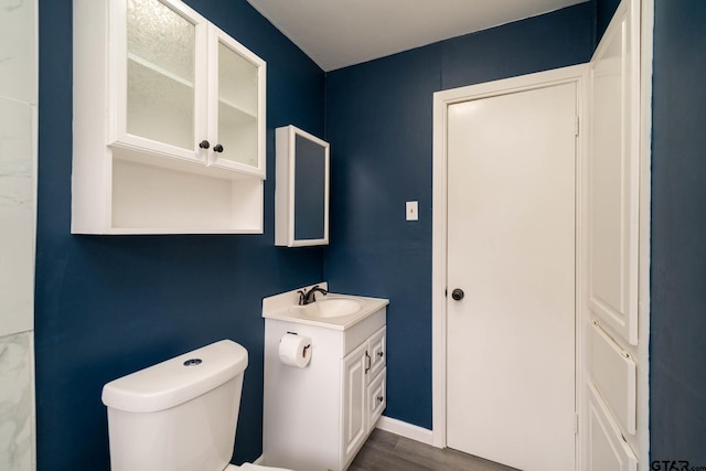 bathroom with toilet, hardwood / wood-style flooring, and vanity