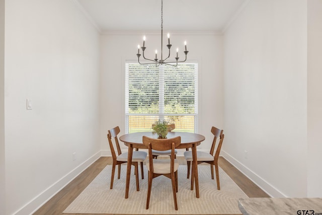 dining space featuring hardwood / wood-style floors, crown molding, and a notable chandelier