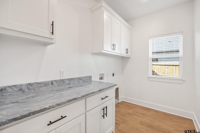 washroom featuring cabinets, hookup for an electric dryer, light hardwood / wood-style floors, and hookup for a washing machine