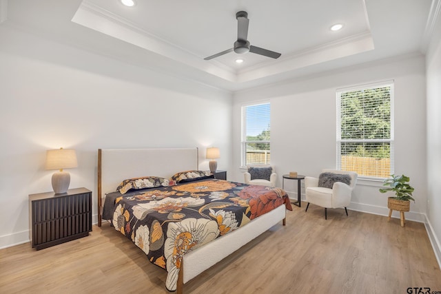 bedroom featuring multiple windows, a raised ceiling, and ceiling fan