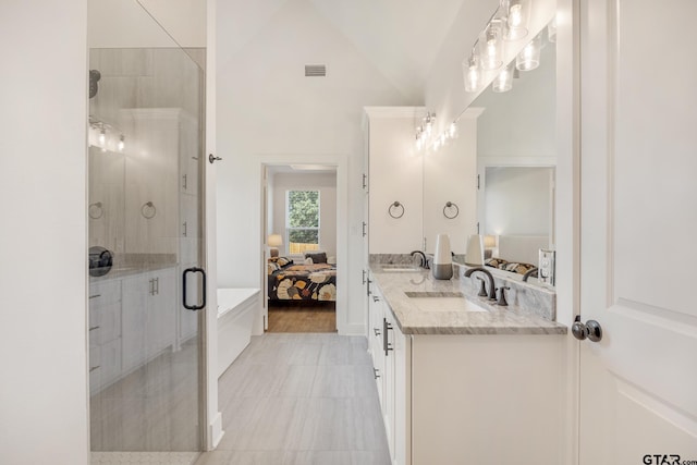 bathroom featuring vanity, a shower with door, and vaulted ceiling