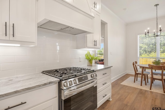 kitchen with backsplash, light stone countertops, white cabinets, stainless steel range with gas cooktop, and custom exhaust hood