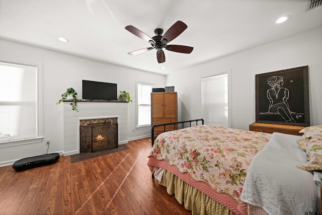 301 W Charnwood St, Tyler, TX 75701 - bedroom with a fireplace with flush hearth, wood finished floors, recessed lighting, a ceiling fan, and baseboards