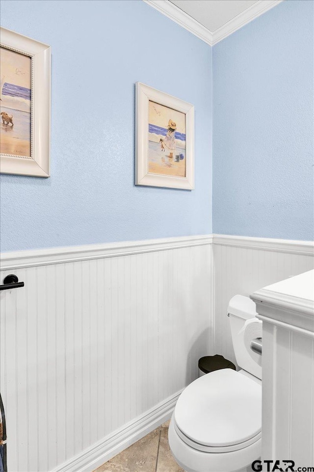 bathroom featuring crown molding and toilet