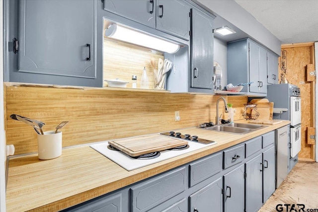 kitchen featuring sink, white appliances, and gray cabinets