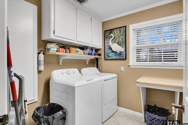 laundry area with cabinets, independent washer and dryer, ornamental molding, and light tile patterned floors