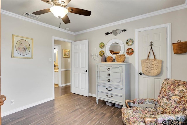 sitting room featuring dark wood-type flooring, ceiling fan, and crown molding