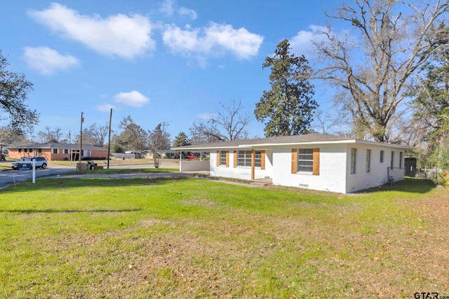 ranch-style house featuring a front lawn and a carport