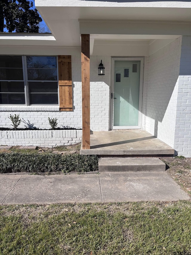 property entrance featuring brick siding