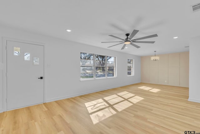 foyer featuring ceiling fan with notable chandelier and light wood-type flooring