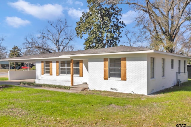 ranch-style home with a carport and a front lawn