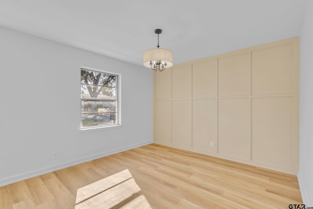 unfurnished dining area with light hardwood / wood-style floors and an inviting chandelier