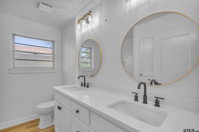 bathroom featuring hardwood / wood-style floors, vanity, toilet, and a wealth of natural light