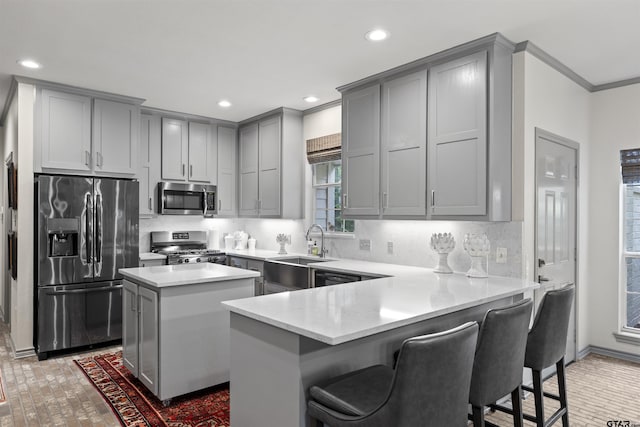 kitchen with gray cabinets, brick floor, a sink, ornamental molding, and stainless steel appliances